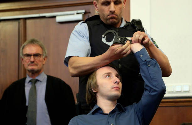 DORTMUND, GERMANY - DECEMBER 21: Defendant Sergej W. (R, seated) is watched by his his lawyer Carl W. Heydenreich (L) as he gets his handcuffs unlocked after arriving at the district court during the trial for the bombing of the Borussia Dortmund bus on December 21, 2017 in Dortmund, Germany. 28-year-old Sergej W. is facing charges of attempted murder for allegedly detonating homemade bombs next to the BVB Dortmund team bus as they travelled to their UEFA Champions League match against Monaco in an attempt to trigger a fall in the football club's shares. (Photo by Friedmann Vogel - Pool/Getty Images)