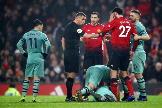 MANCHESTER, ENGLAND - DECEMBER 05: Matteo Darmian of Manchester United, Marouane Fellaini of Manchester United and Shkodran Mustafi of Arsenal speaks to referee Andre Marriner during the Premier League match between Manchester United and Arsenal FC at Old Trafford on December 5, 2018 in Manchester, United Kingdom. (Photo by Clive Brunskill/Getty Images)