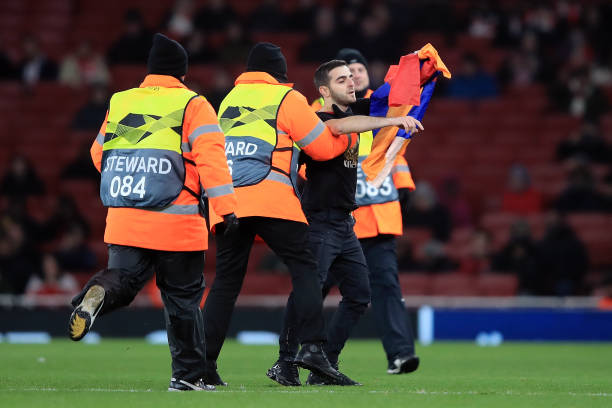 LONDON, ENGLAND - DECEMBER 13:  Pitch invader is escorted from the pitch by stewards during the UEFA Europa League Group E match between Arsenal and Qarabag FK at Emirates Stadium on December 13, 2018 in London, United Kingdom.  (Photo by Marc Atkins/Getty Images)