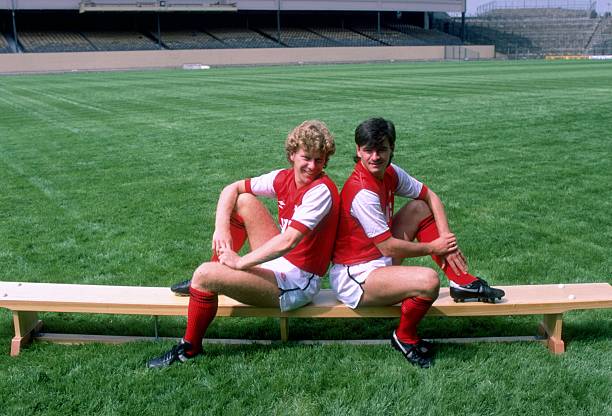Jul 1983: Tony Woodcock (left) and Charlie Nicholas of Arsenal sit on a bench at Highbury in London. Credit: Adrian Murrell/Allsport