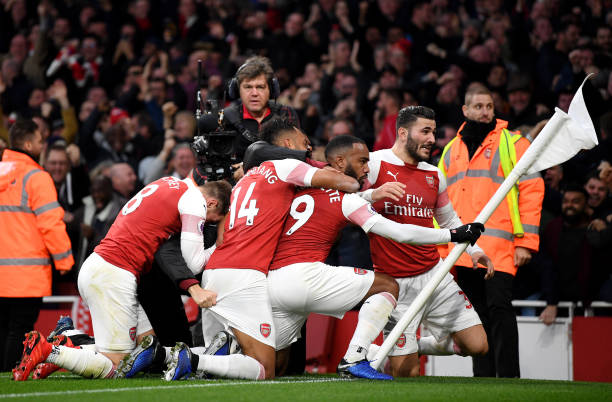LONDON, ENGLAND - DECEMBER 02: Alexandre Lacazette of Arsenal celebrates with teammates after scoring his team's third goal during the Premier League match between Arsenal FC and Tottenham Hotspur at Emirates Stadium on December 1, 2018 in London, United Kingdom. (Photo by Shaun Botterill/Getty Images)