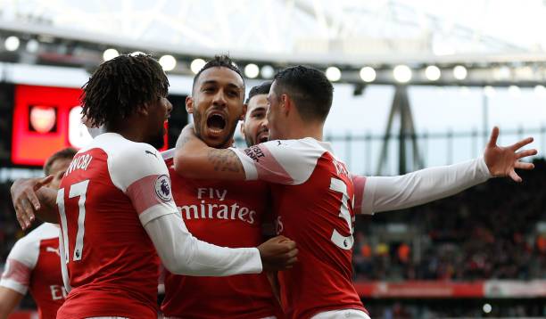 Arsenal's Gabonese striker Pierre-Emerick Aubameyang (C) celebrates with teammates after scoring the opening goal from the penalty spot during the English Premier League football match between Arsenal and Tottenham Hotspur at the Emirates Stadium in London on December 2, 2018. (Photo by Ian KINGTON / IKIMAGES / AFP)