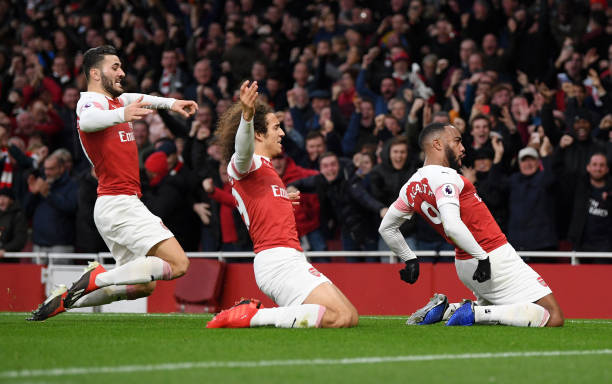 LONDON, ENGLAND - DECEMBER 02: Alexandre Lacazette of Arsenal celebrates with teammates after scoring his team's third goal during the Premier League match between Arsenal FC and Tottenham Hotspur at Emirates Stadium on December 1, 2018 in London, United Kingdom. (Photo by Shaun Botterill/Getty Images)