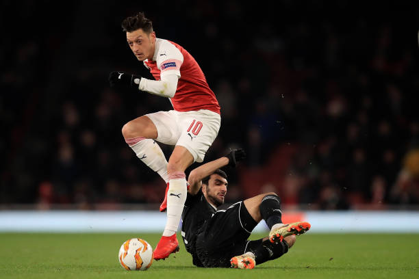 LONDON, ENGLAND - DECEMBER 13: Mesut Ozil of Arsenal is tackled by Mahir Madatov of Qarabag during the UEFA Europa League Group E match between Arsenal and Qarabag FK at Emirates Stadium on December 13, 2018 in London, United Kingdom. (Photo by Marc Atkins/Getty Images)
