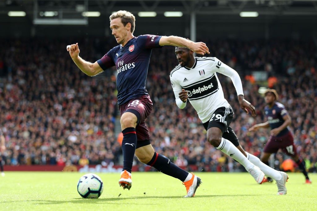 LONDON, ENGLAND - OCTOBER 07: Nacho Monreal of Arsenal runs with the ball under pressure from Andre-Frank Zambo Anguissa of Fulham during the Premier League match between Fulham FC and Arsenal FC at Craven Cottage on October 7, 2018 in London, United Kingdom. (Photo by Bryn Lennon/Getty Images)