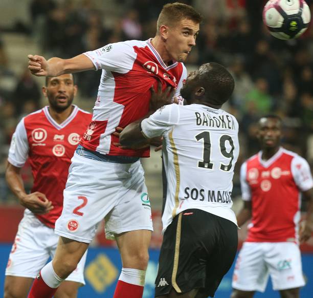 Reims' Belgian defender Björn Engels (L) fights for the ball with Angers' forward Stéphane Bahoken (R) during the French L1 football match between Reims and Angers at The Auguste Delaune Stadium in Reims on October 20, 2018. (Photo by FRANCOIS NASCIMBENI / AFP) 
