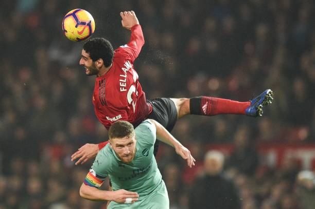 Manchester United's Belgian midfielder Marouane Fellaini (top) out-jumps Arsenal's German defender Shkodran Mustafi (bottom) during the English Premier League football match between Manchester United and Arsenal at Old Trafford in Manchester, north west England, on December 5, 2018. (Photo by Oli SCARFF / AFP)