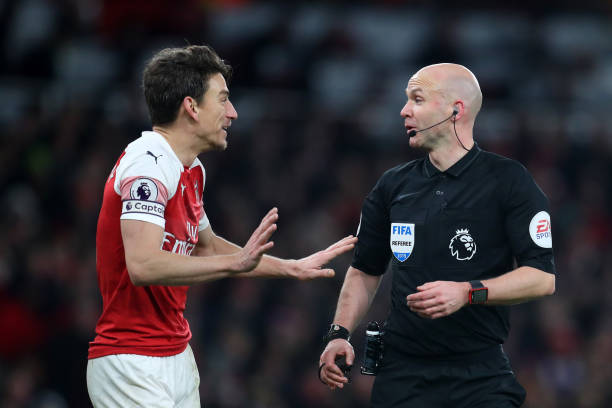 LONDON, ENGLAND - JANUARY 19: Laurent Koscielny of Arsenal speaks with Match Referee Anthony Taylor during the Premier League match between Arsenal FC and Chelsea FC at Emirates Stadium on January 19, 2019 in London, United Kingdom. (Photo by Catherine Ivill/Getty Images)