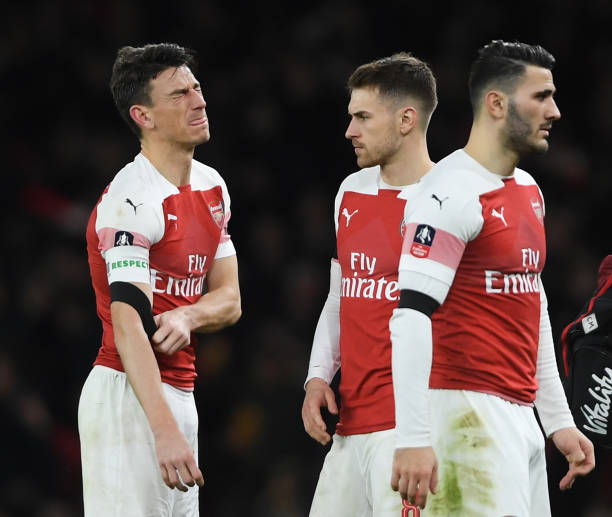 LONDON, ENGLAND - JANUARY 25: An injured Laurent Koscielny of Arsenal leaves the pitch as team mate Aaron Ramsey looks on during the FA Cup Fourth Round match between Arsenal and Manchester United at Emirates Stadium on January 25, 2019 in London, United Kingdom. (Photo by Mike Hewitt/Getty Images)