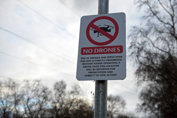 A "No Drones" sign alerting members of the public that the use of drones or unmanned aerial vehicles (UAV) is prohibited, is pictured outside Manchester United's Carrington Training complex in Manchester, north west England on December 20, 2018. - London Gatwick Airport was forced to suspend all flights Thursday due to drones flying over the airfield, causing misery for tens of thousands of stuck passengers just days before Christmas. (Photo by Oli SCARFF / AFP) 