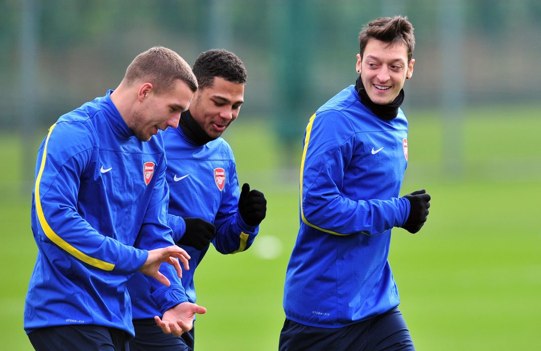 Arsenal's German midfielder Mesut Ozil (R), Arsenal's Polish-born German striker Lukas Podolski (L) and Arsenal's German midfielder Serge Gnabry (2nd L) during a training session at Arsenal's training ground at London Colney, north of London on February 18, 2014, one day ahead of their Champions League last 16, first leg match against Bayern Munich. AFP PHOTO / GLYN KIRK / Getty Images