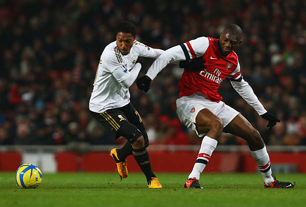 LONDON, ENGLAND - JANUARY 16:  Jonathan de Guzman of Swansea City holds off Abou Diaby of Arsenal during the FA Cup with Budweiser Third Round Replay match between Arsenal and Swansea City at the Emirates Stadium on January 16, 2013 in London, England.  (Photo by Jan Kruger/Getty Images)