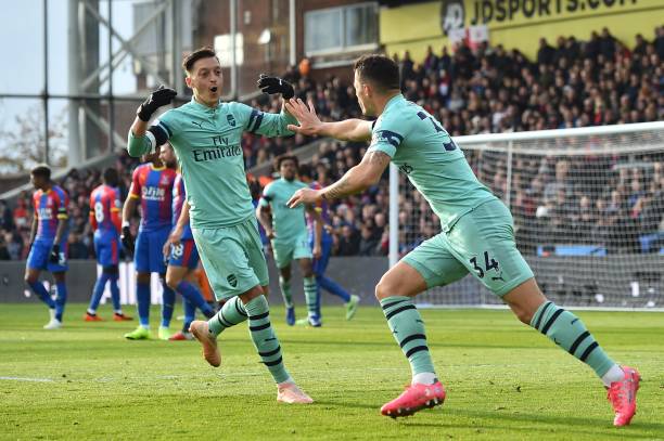 Arsenal's Swiss midfielder Granit Xhaka (R) celebrates with Arsenal's German midfielder Mesut Ozil (L) after scoring their first goal from a free kick to equalise 1-1 during the English Premier League football match between Crystal Palace and Arsenal at Selhurst Park in south London on October 28, 2018. (Photo by Glyn KIRK / AFP)