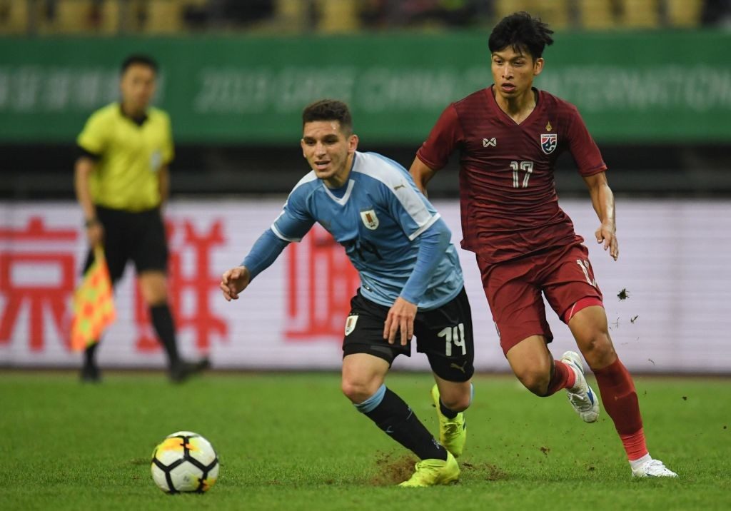 Lucas Torreira (L) of Uruguay competes for the ball with Tanaboon Kesarat of Thailand during the 2019 China Cup final football match between Thailand and Uruguay in Nanning in China's southern Guangxi region on March 25, 2019. (Photo by STR / AFP / Getty Images)