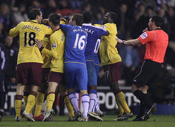 WIGAN, ENGLAND - DECEMBER 29: Referee Lee Probert attempts to break up players from Wigan Athletic and Arsenal as they clash following an incident between Charles N'Zogbia of Wigan Athletic and Marouane Chamakh of Arsenal during the Barclays Premier League match between Wigan Athletic and Arsenal at DW Stadium on December 29, 2010 in Wigan, England. (Photo by Alex Livesey/Getty Images)