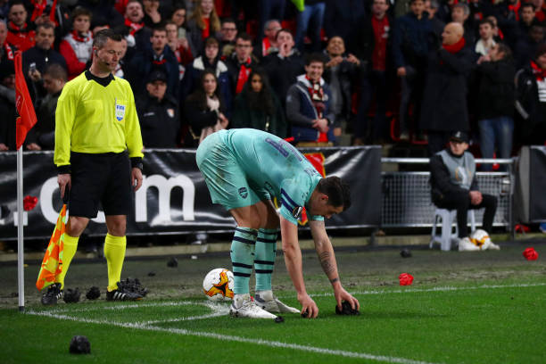 RENNES, FRANCE - MARCH 07: Granit Xhaka of Arsenal collects pieces of screwed up paper thrown by fans from the pitch during the UEFA Europa League Round of 16 First Leg match between Stade Rennais and Arsenal at Roazhon Park on March 07, 2019 in Rennes, France. (Photo by Julian Finney/Getty Images)