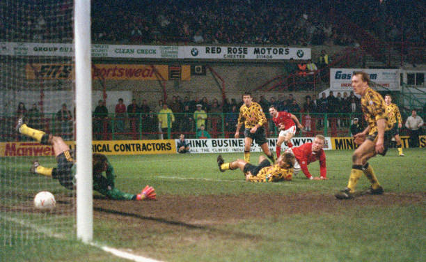 WREXHAM, UNITED KINGDOM - JANUARY 04: Wrexham striker Steve Watkin (2nd r) scores the winning goal past David Seaman watched by left to right, David O' Leary, Tony Adams (floor) Gordon Davies and Lee Dixon during the FA Cup 3rd round match between Fourth Division Wrexham and Arsenal at the Racecourse Ground on January 4, 1992 in Wrexham, Wales. (Photo by Stephen Munday/Allsport/Getty Images)