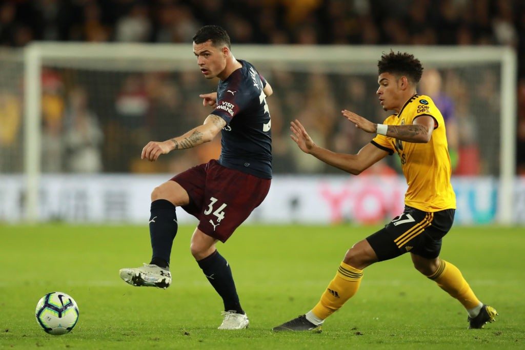 WOLVERHAMPTON, ENGLAND - APRIL 24: Granit Xhaka of Arsenal passes the ball under pressure from Morgan Gibbs-White of Wolverhampton Wanderers during the Premier League match between Wolverhampton Wanderers and Arsenal FC at Molineux on April 24, 2019 in Wolverhampton, United Kingdom. (Photo by David Rogers/Getty Images)