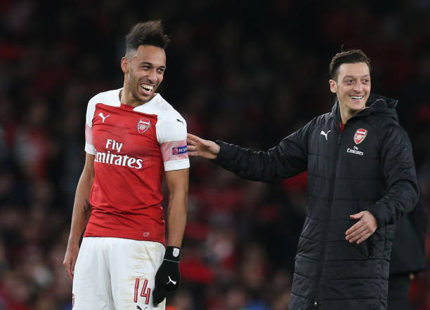 LONDON, ENGLAND - MARCH 14: Pierre-Emerick Aubameyang of Arsenal celebrates with teammate Mesut Ozil at full-time of the UEFA Europa League Round of 16 Second Leg match between Arsenal and Stade Rennais at Emirates Stadium on March 14, 2019 in London, England. (Photo by Alex Morton/Getty Images)
