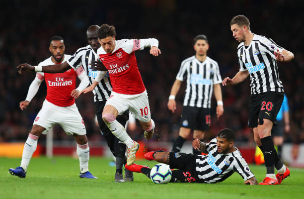LONDON, ENGLAND - APRIL 01: Mesut Ozil of Arsenal evades Mohamed Diame, Deandre Yedlin and Florian Lejeune of Newcastle United during the Premier League match between Arsenal FC and Newcastle United at Emirates Stadium on April 01, 2019 in London, United Kingdom. (Photo by Catherine Ivill/Getty Images)