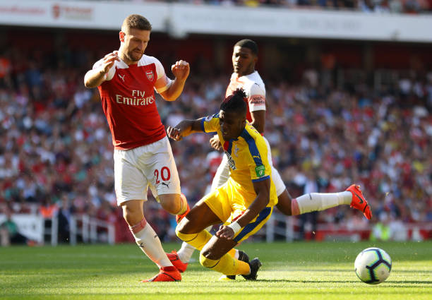 LONDON, ENGLAND - APRIL 21:  Wilfried Zaha of Crystal Palace is challenged by Shkodran Mustafi of Arsenal during the Premier League match between Arsenal FC and Crystal Palace at Emirates Stadium on April 21, 2019 in London, United Kingdom. (Photo by Warren Little/Getty Images)