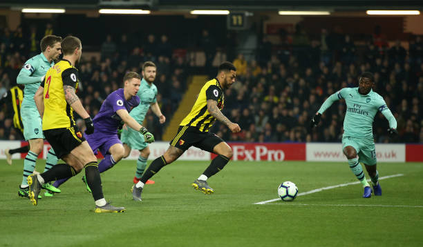 WATFORD, ENGLAND - APRIL 15:  Andre Gray of Watford has his shot at goal blocked by Ainsley Maitland-Niles of Arsenal during the Premier League match between Watford FC and Arsenal FC at Vicarage Road on April 15, 2019 in Watford, United Kingdom. (Photo by Marc Atkins/Getty Images)