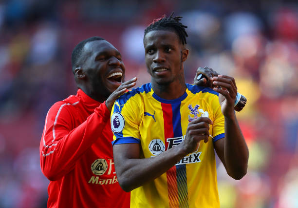 LONDON, ENGLAND - APRIL 21: Wilfried Zaha of Crystal Palace celebrates victory with Christian Benteke after the Premier League match between Arsenal FC and Crystal Palace at Emirates Stadium on April 21, 2019 in London, United Kingdom. (Photo by Warren Little/Getty Images)