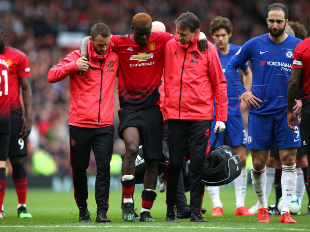 MANCHESTER, ENGLAND - APRIL 28:  An injured Eric Bailly of Manchester United is given assistance during the Premier League match between Manchester United and Chelsea FC at Old Trafford on April 28, 2019 in Manchester, United Kingdom. (Photo by Alex Livesey/Getty Images)