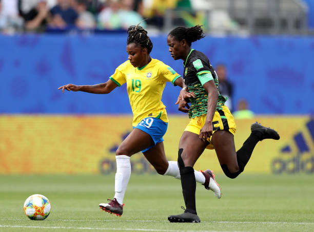 GRENOBLE, FRANCE - JUNE 09: Ludmila #19 of Brazil takes the ball as Konya Plummer #5 of Jamaica defends in the second half during the 2019 FIFA Women's World Cup France group C match between Brazil and Jamaica at Stade des Alpes on June 09, 2019 in Grenoble, France. (Photo by Elsa/Getty Images)