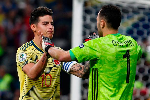Colombia's James Rodriguez (L) greets his teammate goalkeeper David Ospina after scoring his penalty during the penalty shoot-out against Chile after tying 0-0 during their Copa America football tournament quarter-final match at the Corinthians Arena in Sao Paulo, Brazil, on June 28, 2019. (Photo by Miguel SCHINCARIOL / AFP)