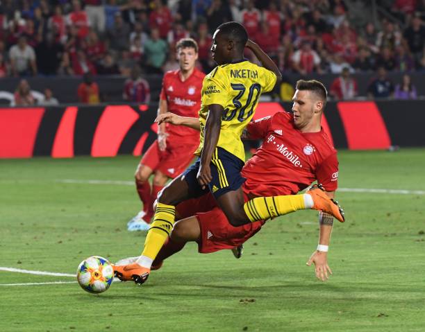 Forward Eddie Nketiah of Arsenal (L) is tackled by Niklas Sule of Bayern Munich during their International Champions Cup game at the Dignity Health Stadium in Carson, California on July 17, 2019. - Arsenal went on to win 2-1. (Photo by Mark RALSTON / AFP)