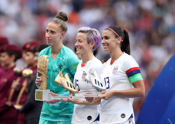 LYON, FRANCE - JULY 07: (L-R) Sari Van Veenendaal of the Netherlands, golden glove, Megan Rapinoe of the USA, golden boot and Alex Morgan of the USA, silver boot celebrate with their respective trophies after the 2019 FIFA Women's World Cup France Final match between The United States of America and The Netherlands at Stade de Lyon on July 07, 2019 in Lyon, France. (Photo by Alex Grimm/Getty Images)