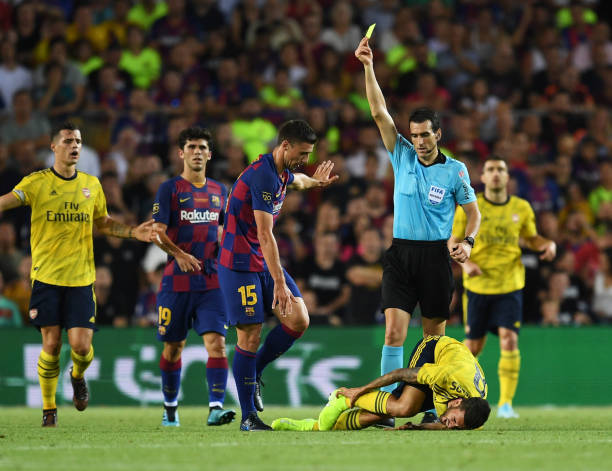 BARCELONA, SPAIN - AUGUST 04: Clement Lenglet of Barcelona is shown a yellow card by referee Juan Martinez Munuera after a challenge on Dani Ceballos of Arsenal during the Joan Gamper Trophy pre-season friendly match between FC Barcelona and Arsenal at Nou Camp on August 04, 2019 in Barcelona, Spain. (Photo by David Ramos/Getty Images)