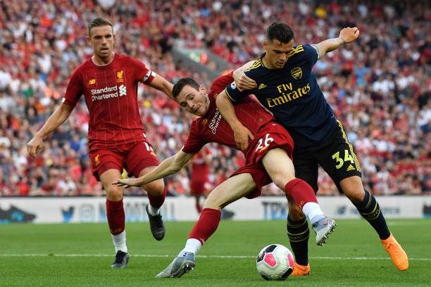 Liverpool's Scottish defender Andrew Robertson (C) vies with Arsenal's Swiss midfielder Granit Xhaka (R) during the English Premier League football match between Liverpool and Arsenal at Anfield in Liverpool, north west England on August 24, 2019. (Photo by Ben STANSALL / AFP)