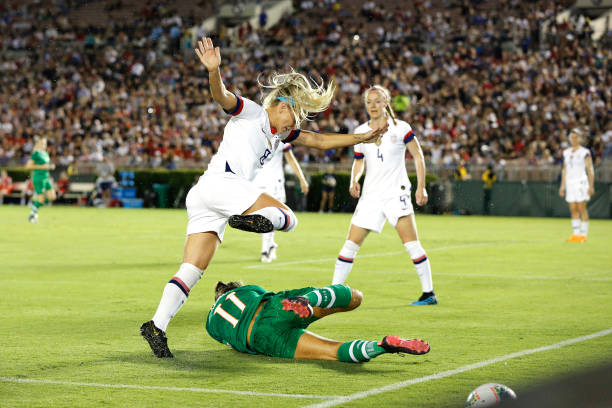 PASADENA, CALIFORNIA - AUGUST 03:    Julie Ertz #8 of United States falls over Katie McCabe #11 of Republic of Ireland during the first half of the first game of the USWNT Victory Tour at Rose Bowl on August 03, 2019 in Pasadena, California. (Photo by Katharine Lotze/Getty Images)