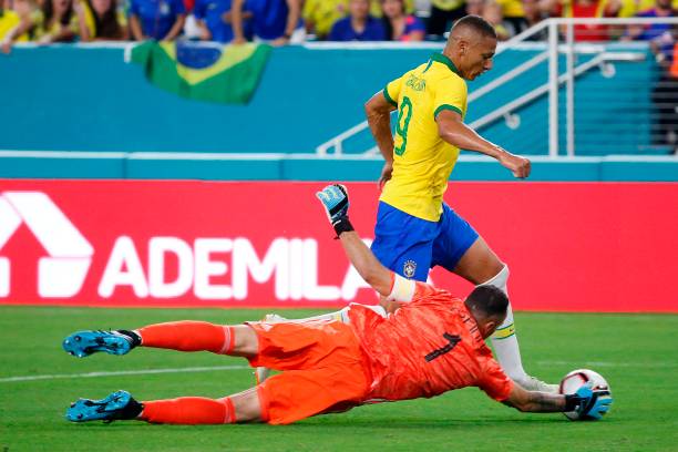 Colombia's goalkeeper David Ospina (Bottom) stops a shot by Brazil's foward Richarlison (Top) during their international friendly football match between Brazil and Colombia at Hard Rock Stadium in Miami, Florida, on September 6, 2019. (Photo by RHONA WISE / AFP)   
