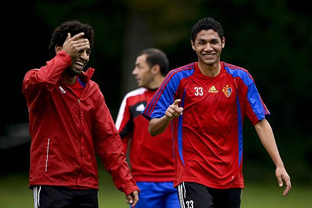 FC Basel's Egyptian midfielder Mohamed Salah (L) shares a light moment with compatriot midfielder Mohamed Elneny (R) during a training session on September 30, 2013 in Basel, on the eve of an UEFA Champions League group E football match against FC Schalke 04. AFP PHOTO / FABRICE COFFRINI  