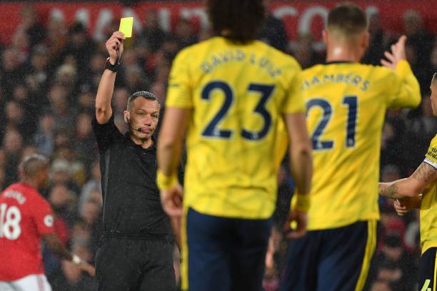 English referee Kevin Friend shows a yellow card to Arsenal's English defender Calum Chambers (R) during the English Premier League football match between Manchester United and Arsenal at Old Trafford in Manchester, north west England, on September 30, 2019. (Photo by Paul ELLIS / AFP)