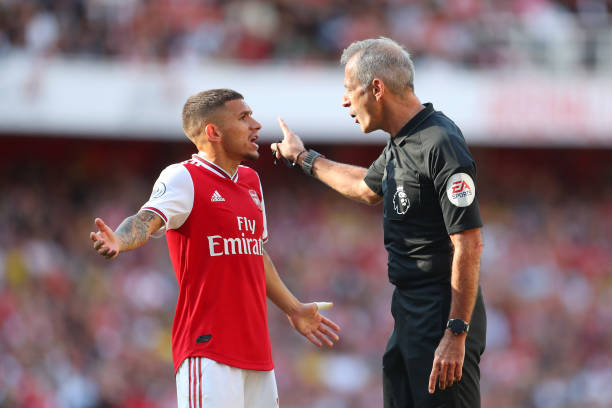 LONDON, ENGLAND - SEPTEMBER 01: Lucas Torreira of Arsenal speaks tp match referee Martin Atkinson during the Premier League match between Arsenal FC and Tottenham Hotspur at Emirates Stadium on September 01, 2019 in London, United Kingdom. (Photo by Catherine Ivill/Getty Images)