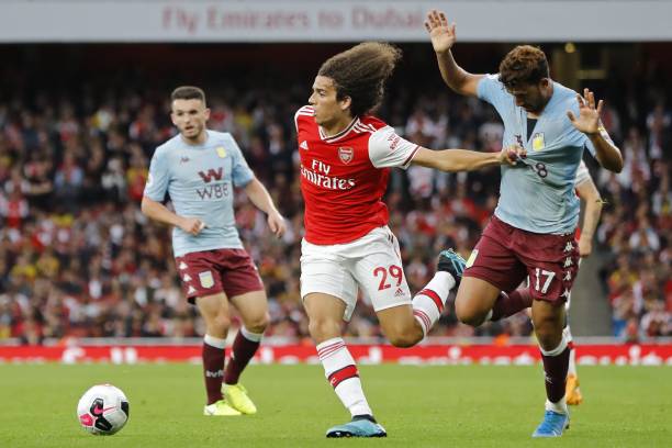 Arsenal's French midfielder Matteo Guendouzi (L) holds the shirt of Aston Villa's Egyptian midfielder Trezeguet as he runs into the penalty area during the English Premier League football match between Arsenal and Aston Villa at the Emirates Stadium in London on September 22, 2019. (Photo by Tolga AKMEN / AFP)