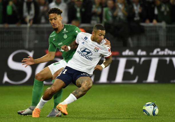 Lyon's Dutch forward Memphis Depay (C) fights for the ball with Saint-Etienne's French defender William Saliba (L) during the French L1 football match between AS Saint-Etienne and Olympique Lyonnais at the Geoffroy Guichard Stadium in Saint-Etienne, central France on October 6, 2019. (Photo by PHILIPPE DESMAZES / AFP) (Photo by PHILIPPE DESMAZES/AFP via Getty Images)