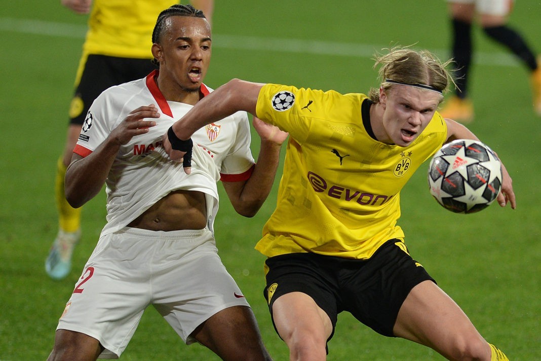 TOPSHOT - Dortmund's Norwegian forward Erling Braut Haaland (R) challenges Sevilla's French defender Jules Kounde during the UEFA Champions League round of 16 first leg football match between Sevilla FC and Borussia Dortmund at the Ramon Sanchez Pizjuan stadium in Seville on February 17, 2021. (Photo by CRISTINA QUICLER / AFP) (Photo by CRISTINA QUICLER/AFP via Getty Images)