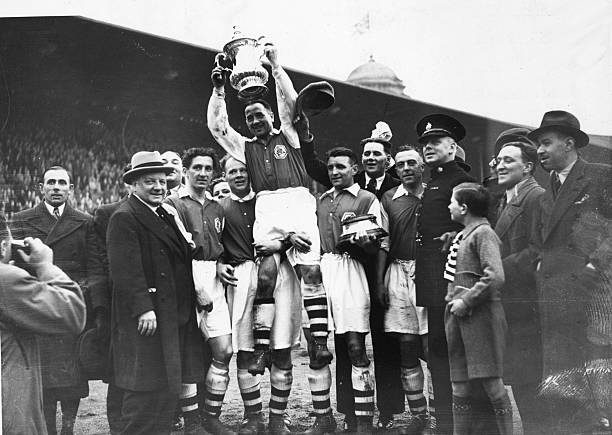 1936: Arsenal's Alex James and the FA Cup trophy are lifted in victory after Arsenal's 1-0 victory over Sheffield United in the FA Cup final at Wembley Stadium. (Photo by Fox Photos/Getty Images)