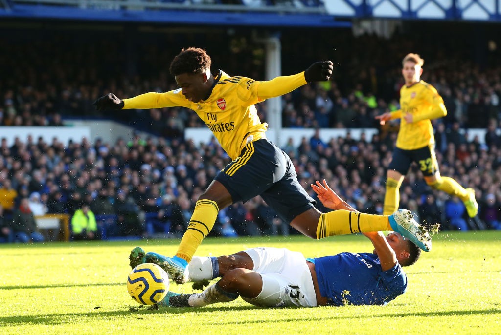 LIVERPOOL, ENGLAND - DECEMBER 21: Yerry Mina of Everton tackles Bukayo Saka of Arsenal during the Premier League match between Everton FC and Arsenal FC at Goodison Park on December 21, 2019, in Liverpool, United Kingdom. (Photo by Alex Livesey/Getty Images)