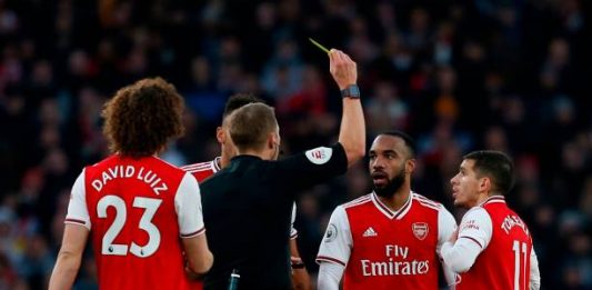 Arsenal's French striker Alexandre Lacazette (2R) is shown a yellow card by referee Craig Pawson during the English Premier League football match between Arsenal and Chelsea at the Emirates Stadium in London on December 29, 2019. (Photo by Ian KINGTON / IKIMAGES / AFP) / RESTRICTED TO EDITORIAL USE. No use with unauthorized audio, video, data, fixture lists, club/league logos or 'live' services. Online in-match use limited to 45 images, no video emulation. No use in betting, games or single club/league/player publications. (Photo by IAN KINGTON/IKIMAGES/AFP via Getty Images)