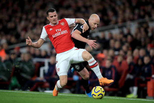 LONDON, ENGLAND - DECEMBER 05: Granit Xhaka of Arsenal in action with Aaron Mooy of Brighton and Hove Albion during the Premier League match between Arsenal FC and Brighton & Hove Albion at Emirates Stadium on December 5, 2019 in London, United Kingdom. (Photo by Marc Atkins/Getty Images)