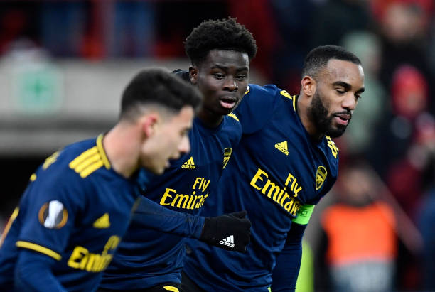 Arsenal's English striker Bukayo Saka (C) celebrates with teammate Arsenal's French striker Alexandre Lacazette (R) after scoring a goal during the UEFA Europa League Group F football match between R. Standard de Liege and Arsenal FC at the Maurice Dufrasne Stadium in Sclessin on December 12, 2019. (Photo by JOHN THYS / AFP) (Photo by JOHN THYS/AFP via Getty Images)