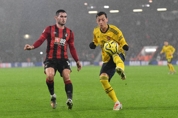 BOURNEMOUTH, ENGLAND - DECEMBER 26: Mesut Ozil of Arsenal battles for possession with Lewis Cook of AFC Bournemouth during the Premier League match between AFC Bournemouth and Arsenal FC at Vitality Stadium on December 26, 2019 in Bournemouth, United Kingdom. (Photo by Justin Setterfield/Getty Images)