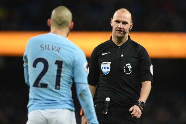 English referee Robert Madley (R) speaks with Manchester City's Spanish midfielder David Silva during the English Premier League football match between Manchester City and West Bromwich Albion at the Etihad Stadium in Manchester, north west England, on January 31, 2018. / AFP PHOTO / Oli SCARFF