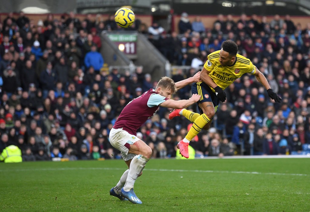 BURNLEY, ENGLAND - FEBRUARY 02: Pierre-Emerick Aubameyang of Arsenal wins a header under pressure from Charlie Taylor of Burnley during the Premier League match between Burnley FC and Arsenal FC at Turf Moor on February 02, 2020, in Burnley, United Kingdom. (Photo by Gareth Copley/Getty Images)